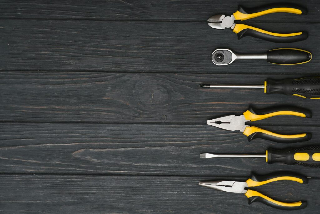 Set of assorted work carpentry and locksmith tools on a dark wooden background with copy space